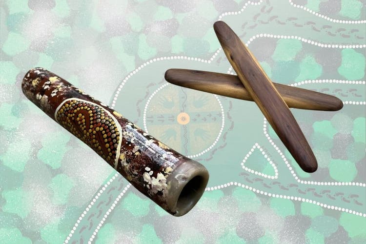 An emu caller and clapsticks over an Aboriginal painting