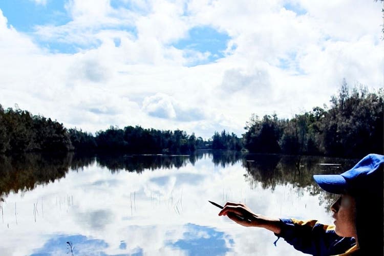 A student pointing to something on the lagoon