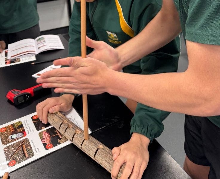 Students attempting to start a fire using traditional tools